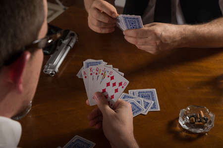 poker cards and handgun at table