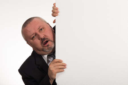 Mature businessman holding a white panel and gesturing isolated on white backgroundの写真素材