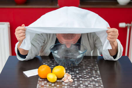 Mature man with colds and flu. Inhalation of herbsの写真素材