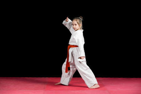 Little girl practice karate isolated on black.の写真素材