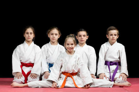 Children in kimono sitting on tatami on martial arts seminar. Selective focus.の写真素材