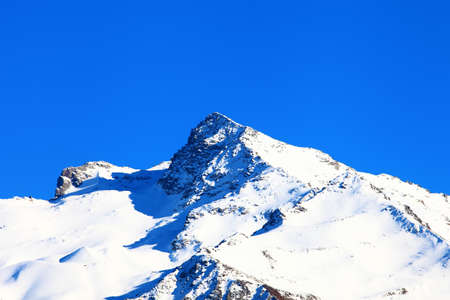 Snow-capped mountains under the crystal blue skyの写真素材