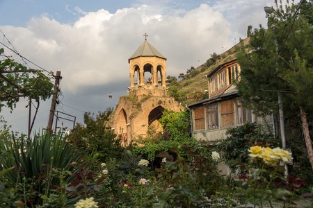 Old dilapidated church on a mountainside in a wild rose garden