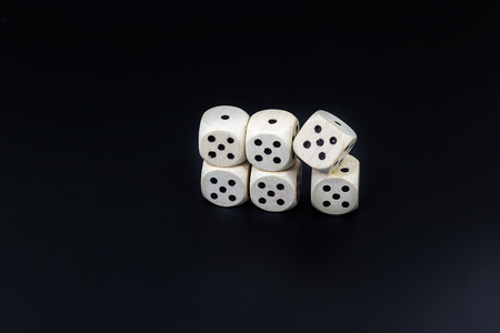 Worn white dices on a black matte backgroundの写真素材
