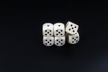 Worn white dices on a black matte background
