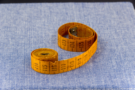 Jeans fabric for sewing,accessories for needlework on new jeans background. Spool of thread, scissors, thimble, tapemeasure , sewing supplies. Set for needlework top viewの写真素材