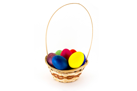 Easter eggs in wicker basket isolated on white backgroundの写真素材