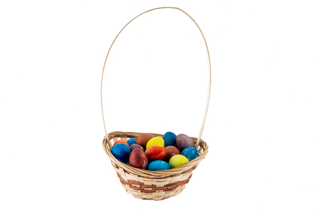 Easter eggs in wicker basket isolated on white backgroundの写真素材
