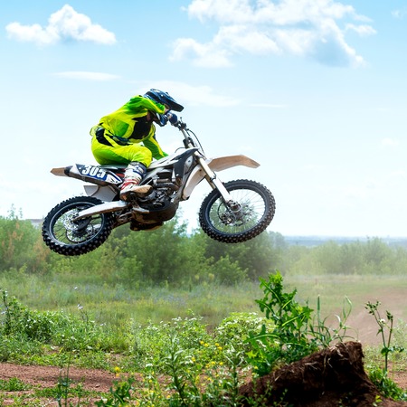 The young sportsman on a motorcycle jumpの写真素材
