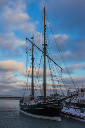 Historic sailing ship frozen in the water near the pier in Tallinn. Estonia