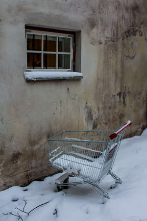 A supermarket basket is abandoned in a snowdrift in an alley in Tallinn's Old Town. Estoniaの写真素材