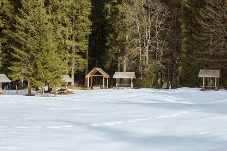 Wooden picnic gazebo in the snow-covered Carpathian Mountains. Road to the highest mountain of...