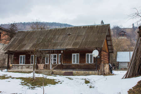 Old wooden rural house in a typical Carpathian village in winter. Ukraineのeditorial素材