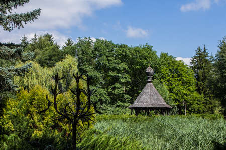 The roof of a wooden gazebo can be seen over the reeds in the open-air museum in Pereyaslav. Ukraineのeditorial素材