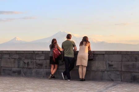 Young people look at Mount Ararat from the hill in Yerevan city. Armenia
