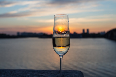 Champagne glasses against the background of the Left Bank of the city of Kyiv at dawn. Ukraineの写真素材