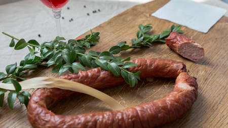 Smoked sausage ring with herbs in rustic style