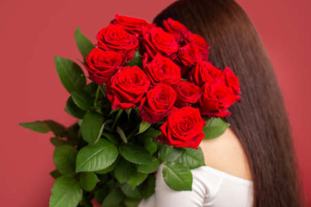 The girl with big bouquet of flower roses on her shoulderの写真素材