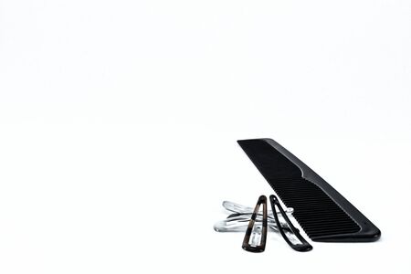  Black plastic saw toothed comb with hair clips, all on white.の写真素材