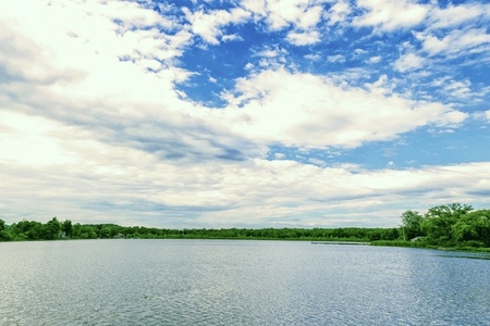 Clear view of a calm lake with a cloudy sky overtop の写真素材