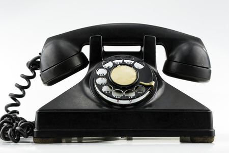 Surface level view of old black rotary dial phone 