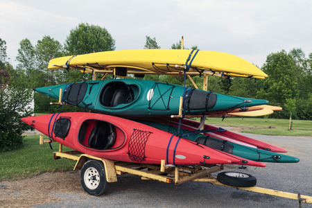 Trailer full of six colorful one man kayaks in a parking lot. の写真素材