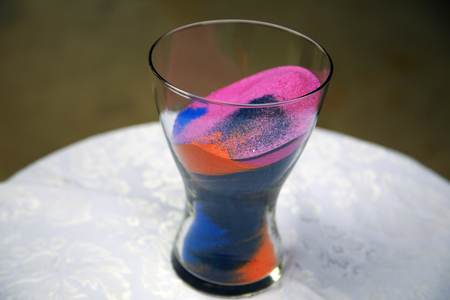Colorful sand including pink, blue, and orange inside a glass vase.の写真素材