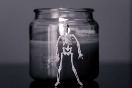 A skeleton, a girl and a candle. Black and white.の写真素材