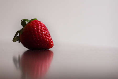 A single, red, organic strawberry is washed and ready to be consumed.の写真素材