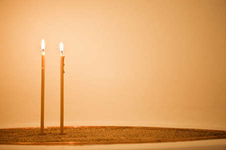 Two candles are burning in church's bowl with sendの写真素材