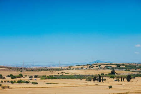 Typical cyprian panoramic view of desert landscape with little trees and bushesの写真素材