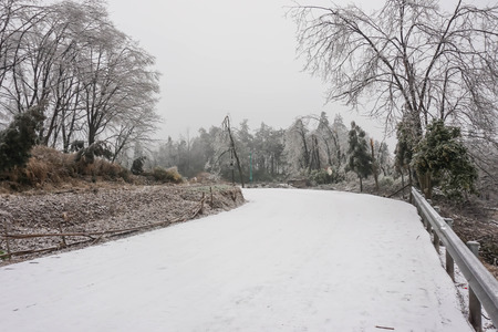 The road covered with snow in Zhangjiajie National Forest Park in winter season with foggy weather ,Zhangjiajie,hunan province,Chinaの写真素材