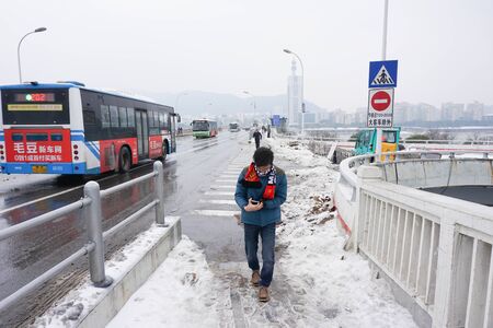 Zhangjiajie,Hunan,China - January 28 2018 :The boy walking straight on the road that covered by snow in winter seasonのeditorial素材