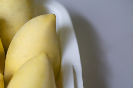 Close up  ripe mangoes in the white basket on grey background,left sideの写真素材