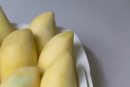 ripe mangos in the white basket on grey backgroundの写真素材