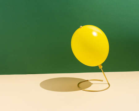 Minimal colorful concept of yellow balloon as globe. Creative idea on green background.の写真素材