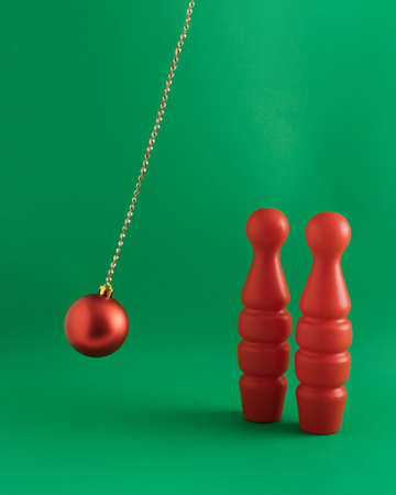 Christmas red bauble on decorative chain with cones. Minimal New Year concept of bowling.の写真素材