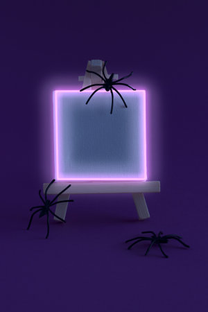 Fluorescent canvas for painting with spiders on purple background. Minimal Halloween concept with copy space.の写真素材