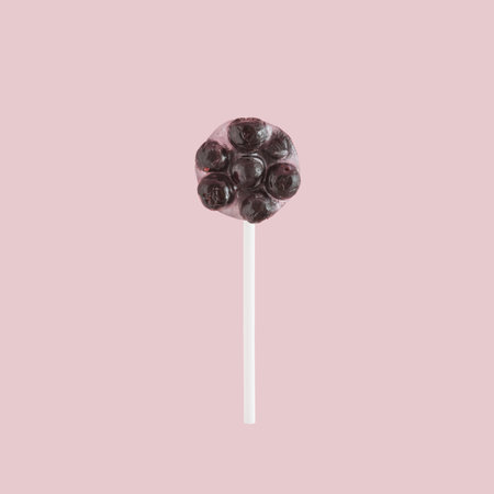Creative idea of 
lollipop with frozen berry fruit, chokeberry, on pink background. Minimal healthy candy concept.の写真素材