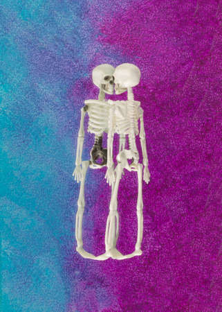 Halloween arrangement made of skeleton reflected on a purple-blue background. Minimal scary and Halloween concept. Trendy colors background.の写真素材