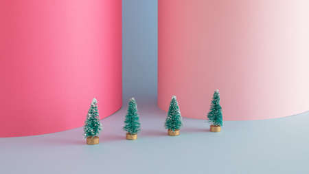 Creative Christmas arrangement made of Christmas trees on a blue and pink backgorund. Minimal New Year concept.の写真素材