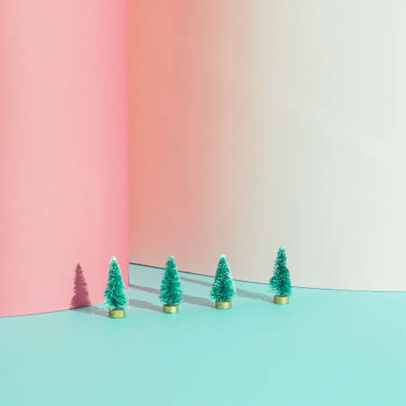 Creative Christmas arrangement made of Christmas trees on a blue and pink backgorund. Minimal 
New Year concept.の写真素材