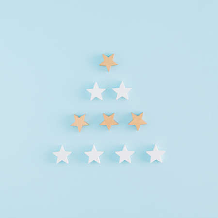 Creative Christmas tree arrangement made of wooden stars on a blue backgorund with copy space. Minimal flat lay andNew Year concept.の写真素材