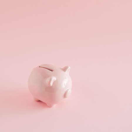 Pink piggy bank on a pink background. Minimal savings concept. International savings day inspiration.の写真素材