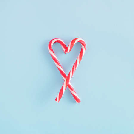 Creative arrangement made of a heart shaped from Christmas sticks on a blue background. Minimal New...