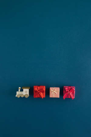 Creative arrangement made of locomotive and New Year's stuff on a blue background. Minimal vertical flat lay concept. Christmas phone wallpapers. Gift delivery inspiration.の写真素材