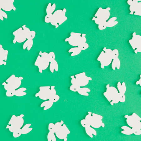 Creative pattern made of white rabbits on a green background. Minimal flat lay concept. Easter...