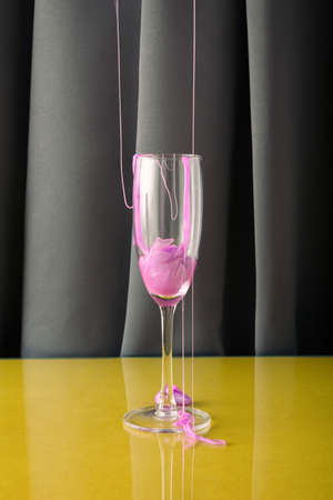 A creative arrangement made of a champagne glass over which purple is poured. Minimal drinking...