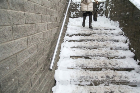 woman climbs the stairs in the snowの写真素材