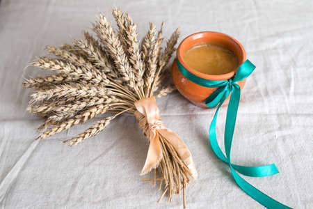 A pot of honey on linen cloth beside the oats.の写真素材